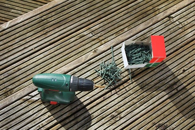 A drill and screws on some decking boards