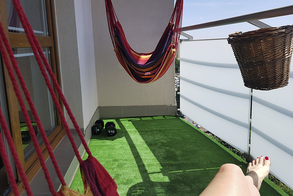 A hammock overhangs artificial grass.